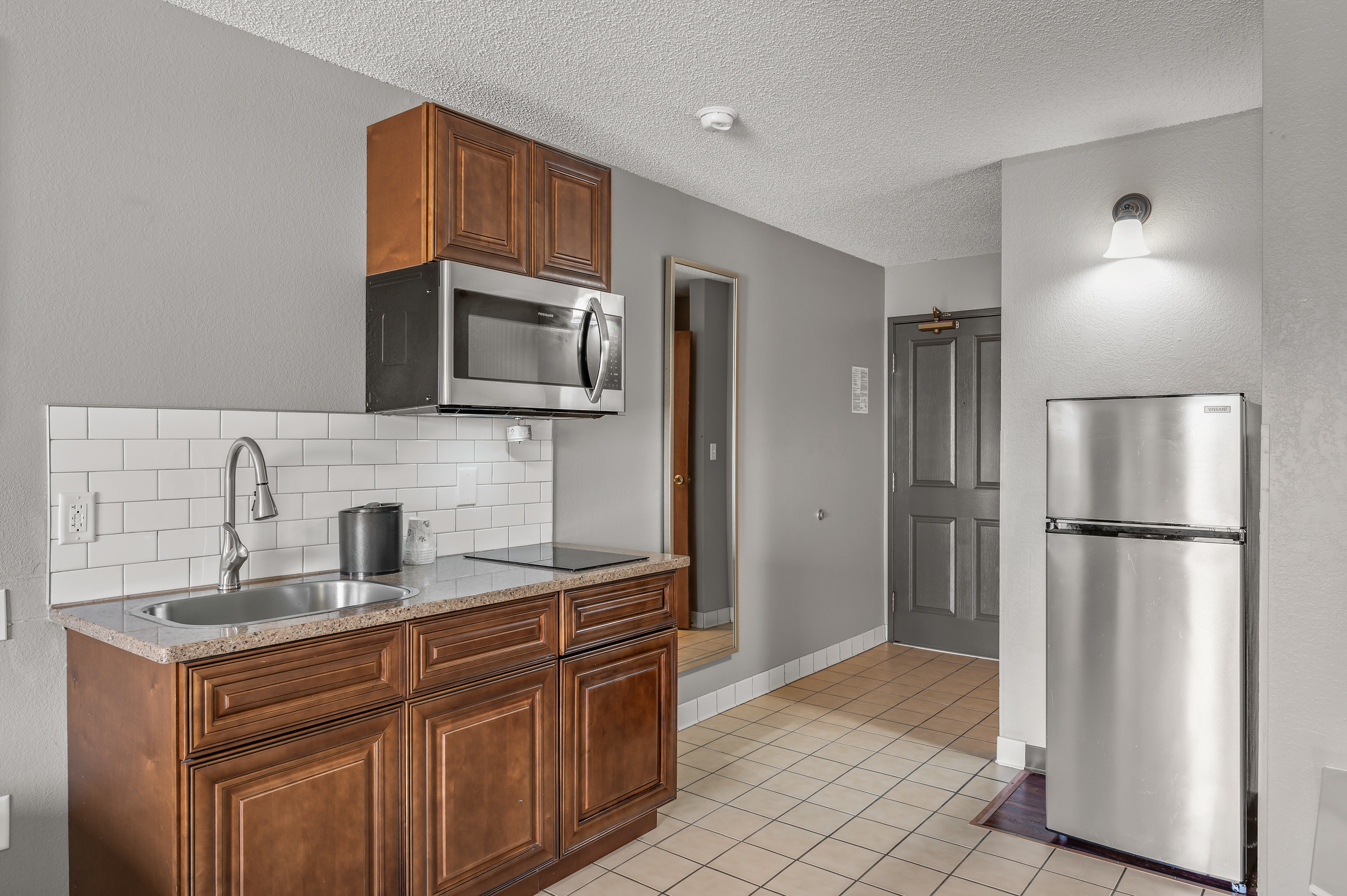 Full kitchenette with granite counters and stainless appliances at TownSquare Place
